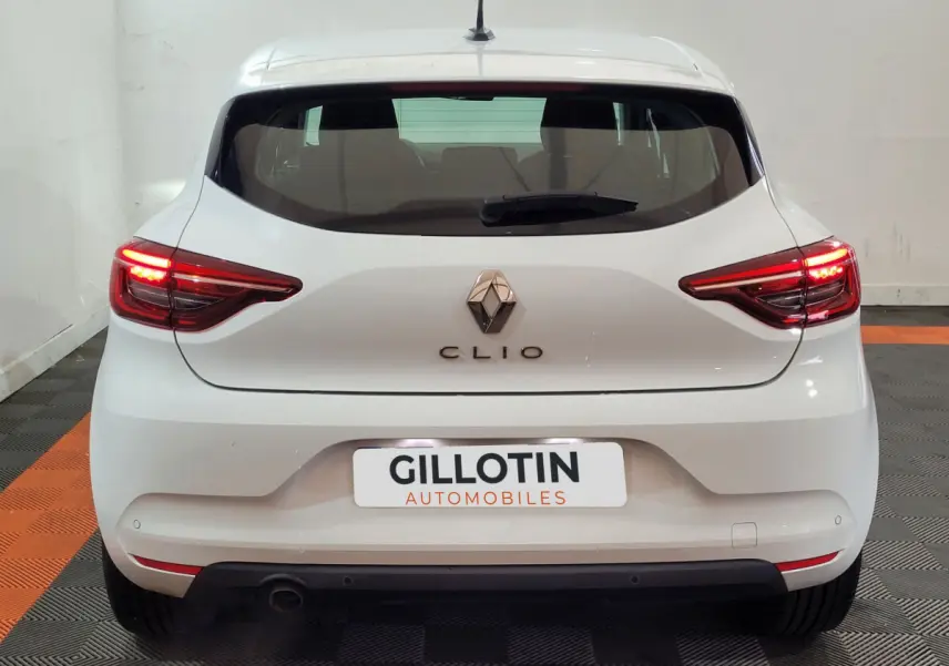 Vue arrière d'une Renault Clio Business blanche avec feux LED allumés dans un garage.