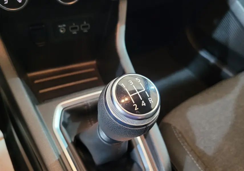 Gros plan sur le levier de vitesses manuel noir de la Renault Clio Business blanche, avec console centrale visible.