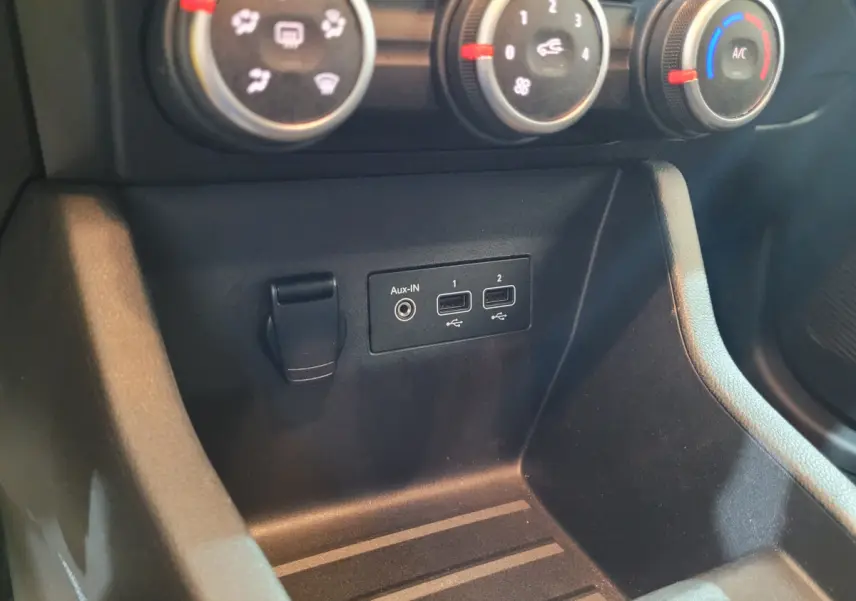 Gros plan sur la console centrale noire de la Renault Clio Business avec commandes climatisation et ports USB visibles.