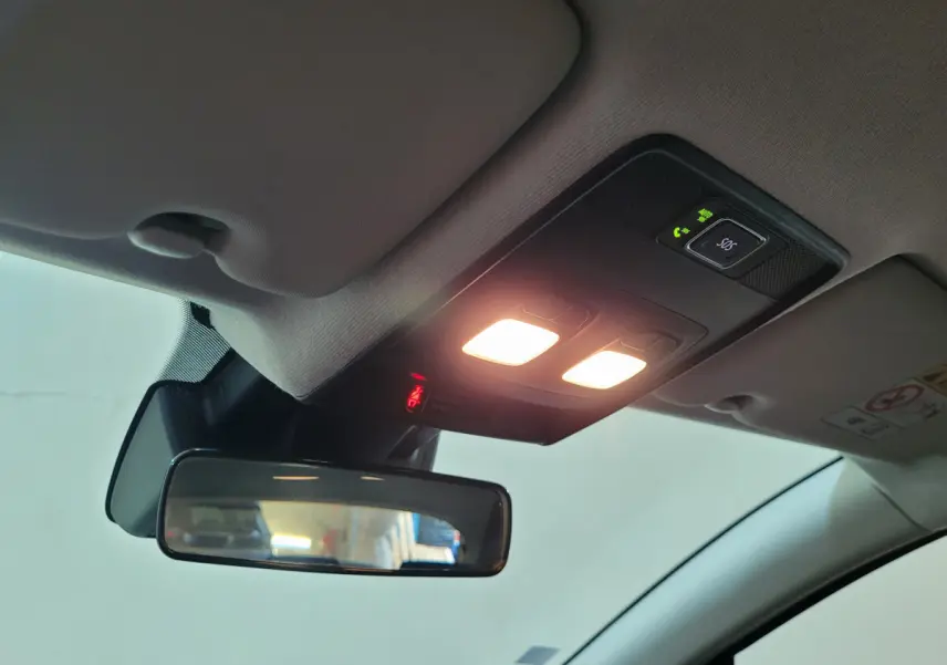 Vue intérieure du plafonnier et rétroviseur central de la Renault Clio Business blanche de 2021 avec éclairage allumé.