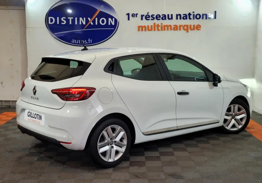 Renault Clio Business blanche vue de profil côté droit dans un showroom avec logo Distinxion en arrière-plan.
