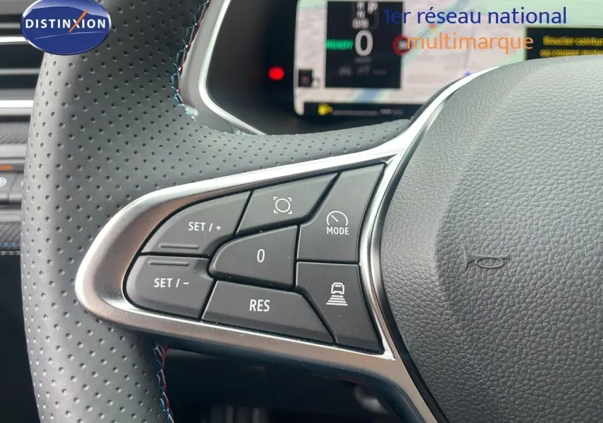 Gros plan sur les commandes au volant en cuir perforé du Renault Captur E-Tech hybride 2025, côté gauche.
