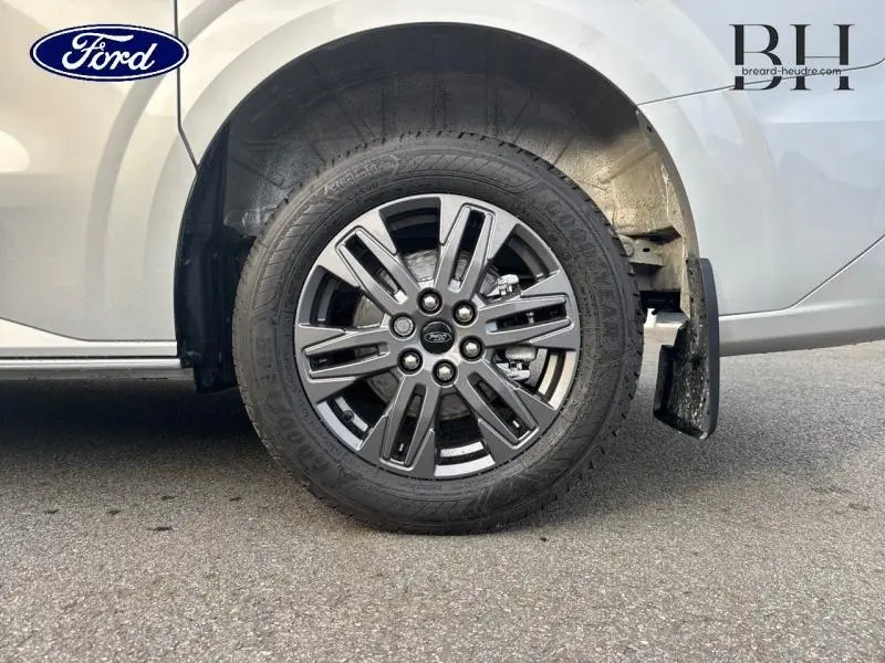 Gros plan sur la roue arrière droite du Ford Transit Custom gris lunaire métallisé avec jante alu gris carbone à 6 branches.