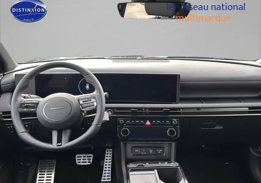 Vue intérieure avant du Hyundai Tucson 2026 gris Shadow, volant cuir multifonction avec surpiqûres rouges et écran tactile large.