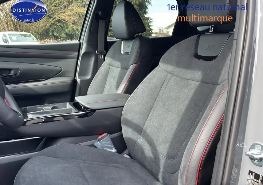 Vue intérieure côté droit sur les sièges avant gris avec surpiqûres rouges et logo N du Hyundai Tucson 2026.