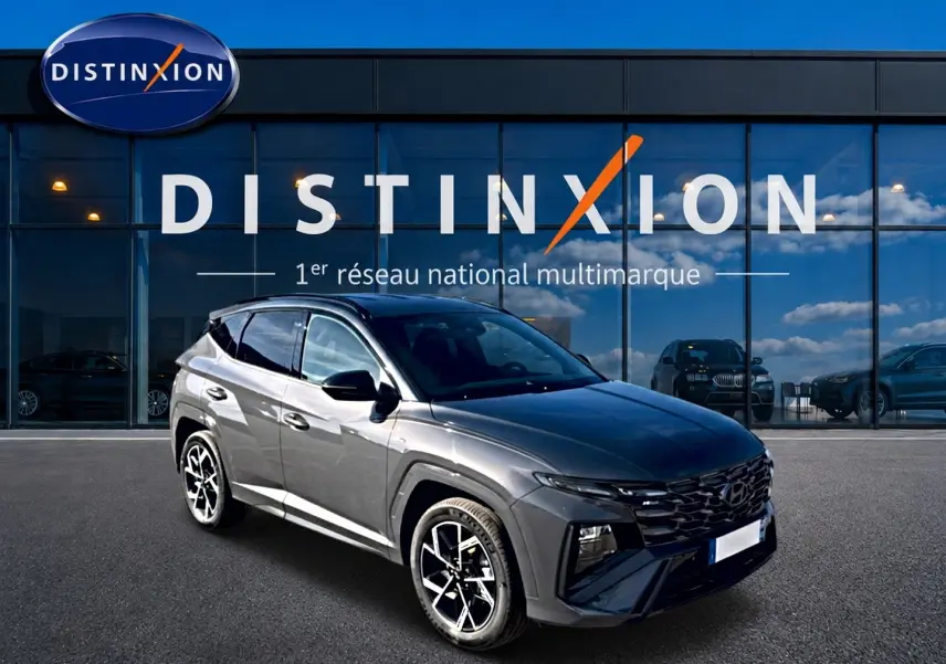Hyundai Tucson gris écotronique en 3/4 avant droit, avec calandre glossy black et jantes alliage 19 pouces.