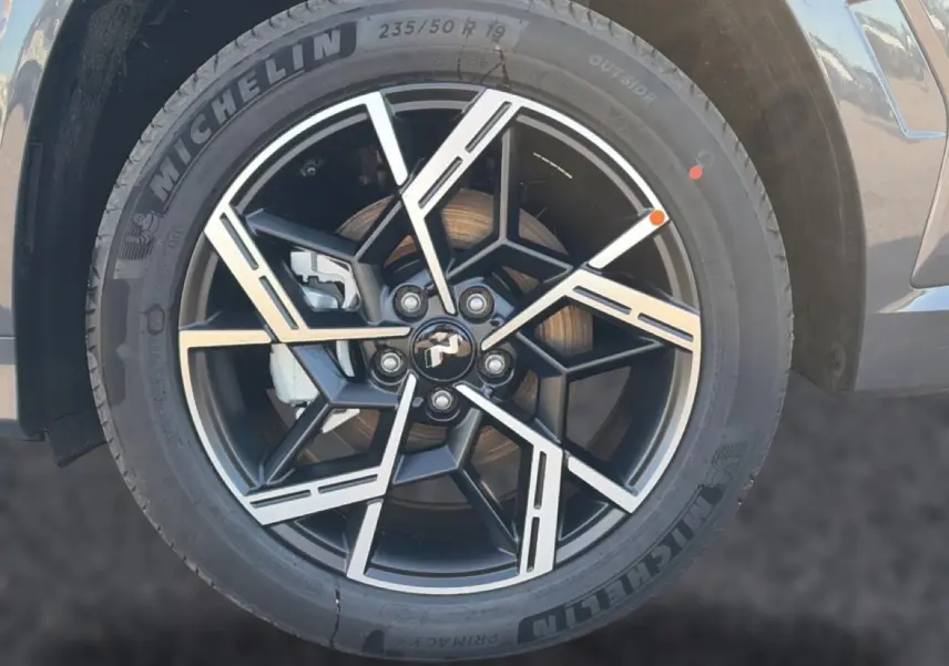 Gros plan sur la jante alliage 19 pouces noire et argentée du Hyundai Tucson gris ecotronique, côté avant droit.