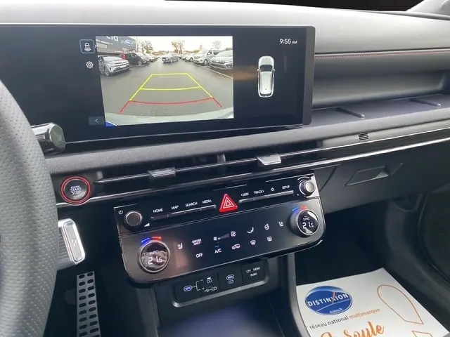 Vue intérieure du tableau de bord du Hyundai Tucson 2026 avec écran de recul et commandes climatisation tactiles.