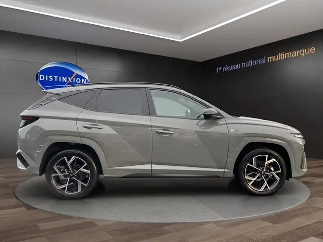 Vue latérale droite du Hyundai Tucson 1.6 Hybrid N Line Creative gris foncé, avec jantes alliage et hayon motorisé visible.