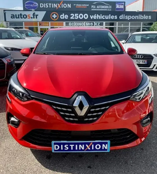 Vue frontale d'une Renault Clio V rouge 2021 avec calandre noire et logo Renault proéminent.