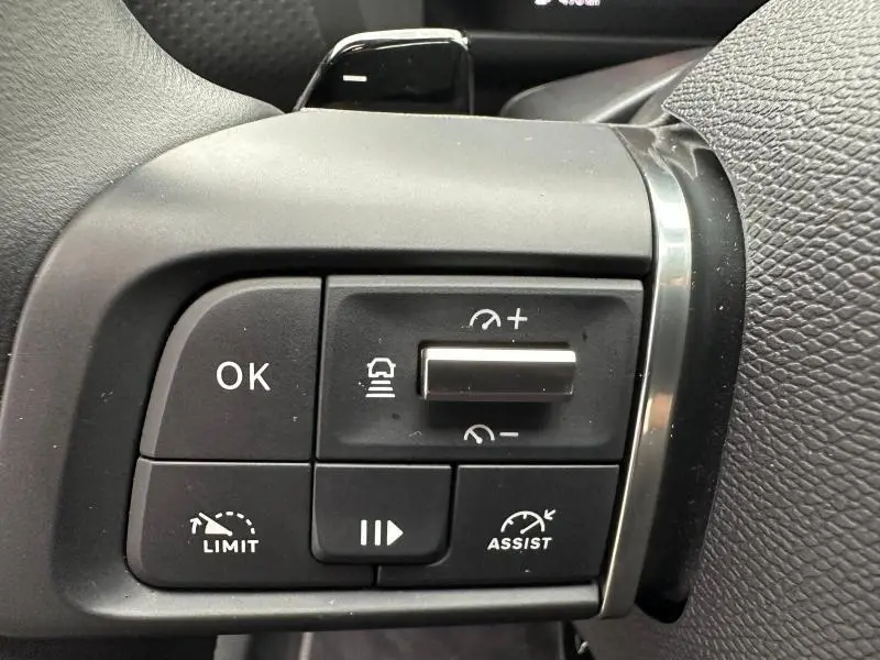 Gros plan sur les commandes noires au volant du Citroën C4 X 2025, avec boutons de régulateur et limiteur de vitesse.