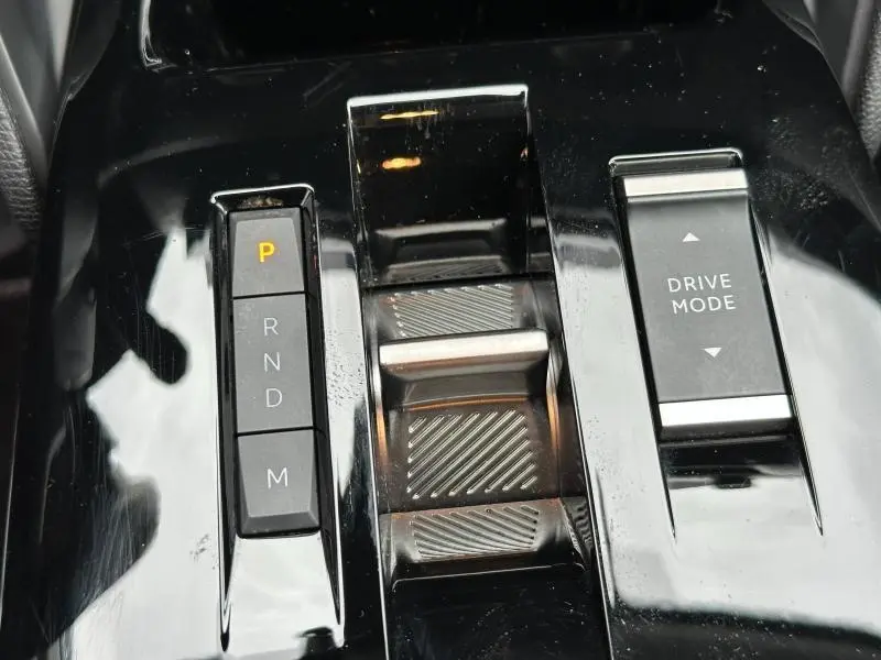 Gros plan sur la console centrale noire brillante du Citroën C4 X 2025, avec commandes boîte auto et mode de conduite.