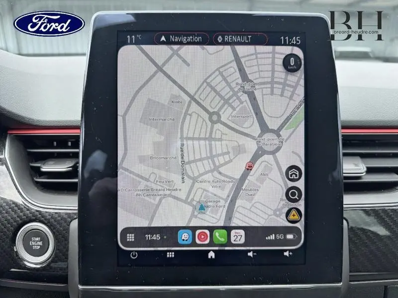 Vue rapprochée de l’écran tactile central du Renault Arkana 2023 avec navigation affichée et tableau de bord gris métallique.