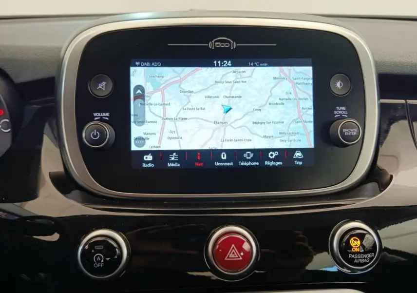 Vue rapprochée de l’écran tactile central du tableau de bord de la Fiat 500X blanc, affichant une carte de navigation.
