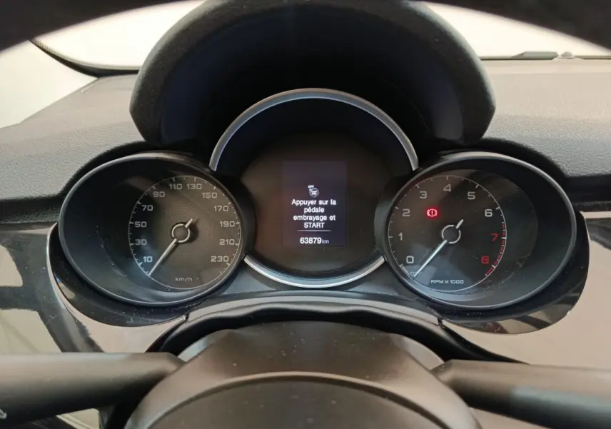 Vue rapprochée du tableau de bord noir de la Fiat 500X 2020, affichant le compteur et l'écran central digital.