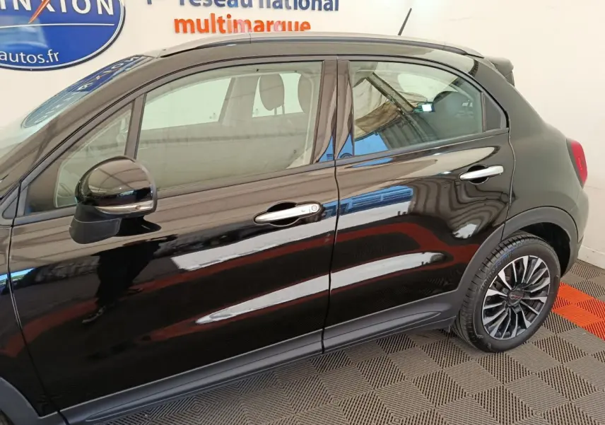 Vue latérale droite d'une FIAT 500X noire avec jantes alliage et rétroviseurs assortis.