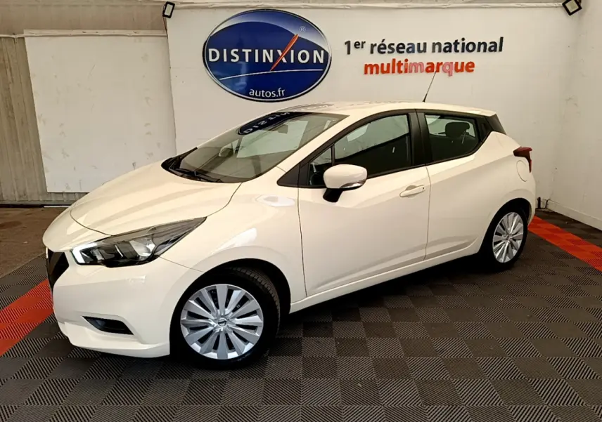 Nissan Micra IG-T 92 Acenta blanche vue de côté droit en intérieur, avec jantes argentées et phares avant visibles.