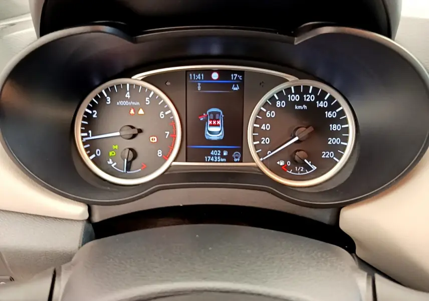 Tableau de bord de Nissan Micra blanc 2022, affichage digital central et compte-tours et vitesse analogiques.