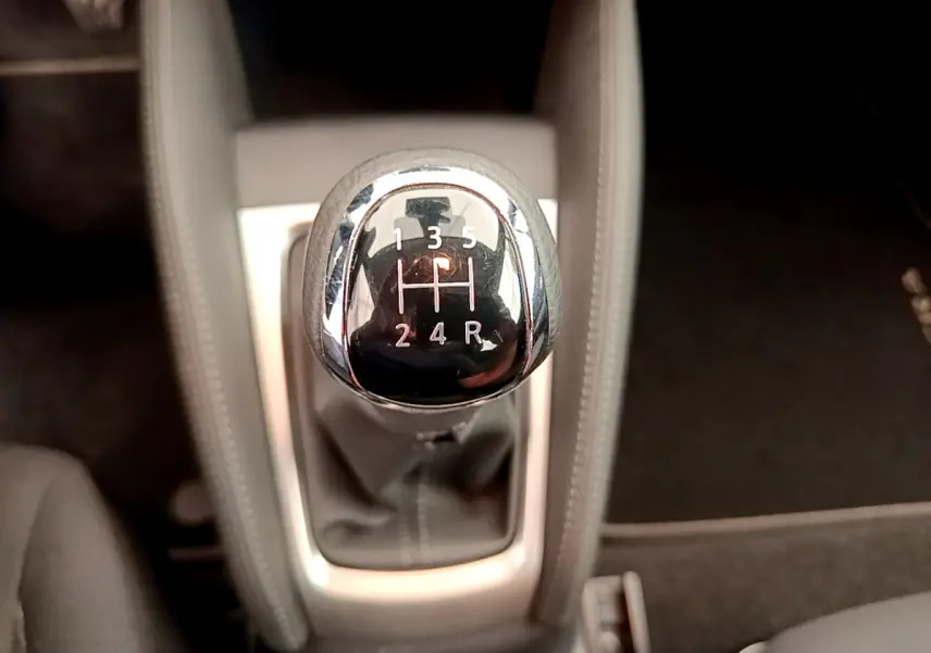 Le levier de vitesse manuel vu de dessus dans l'habitacle de la Nissan Micra blanche 2022 Acenta.