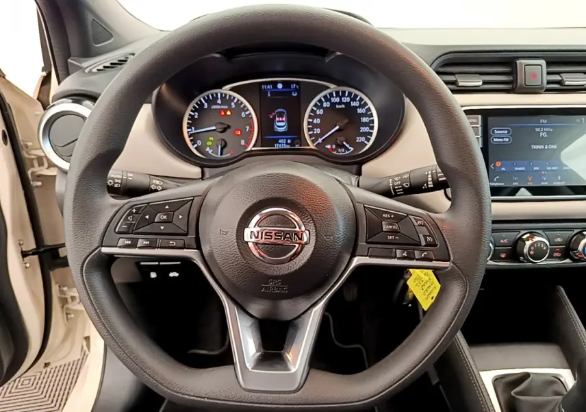 Vue rapprochée du volant noir multifonctions et du tableau de bord digital de la Nissan Micra blanche 2022.