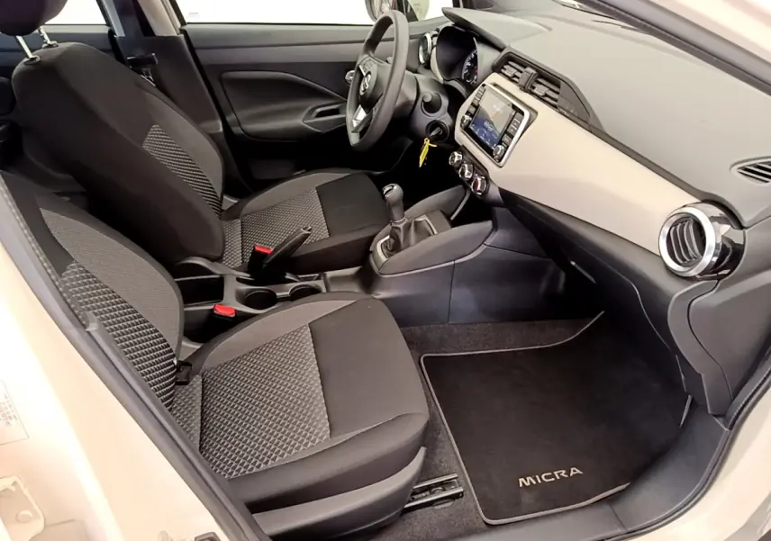 Intérieur avant droit de la Nissan Micra IG-T 92 Acenta 2022, sièges tissu gris et tableau de bord clair avec écran tactile.