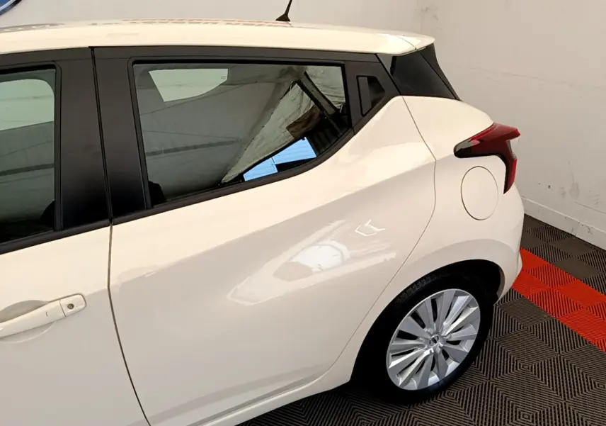 Vue côté gauche arrière d'une Nissan Micra blanche 2022 avec poignées intégrées et feux arrière anguleux.