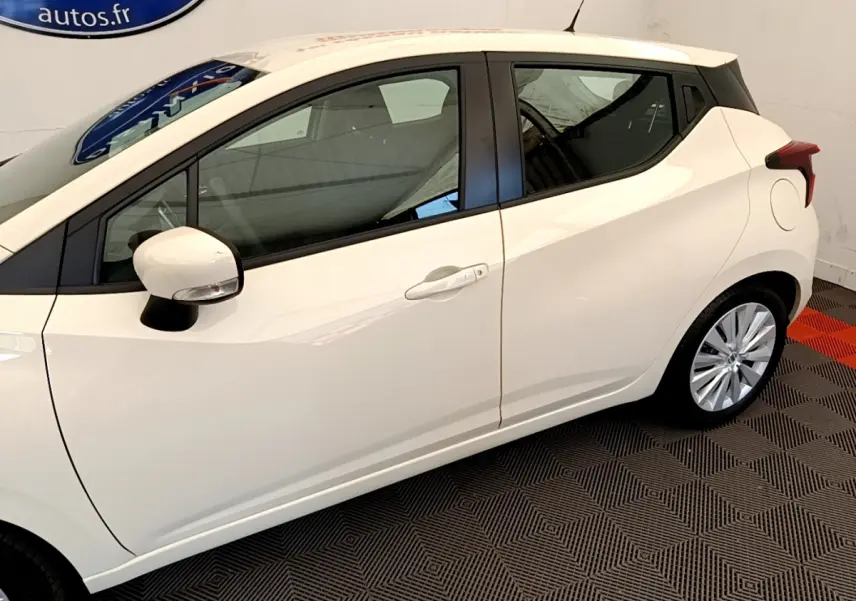 Vue latérale côté gauche d'une Nissan Micra IG-T 92 Acenta blanche avec jantes alliage et rétroviseur assorti.