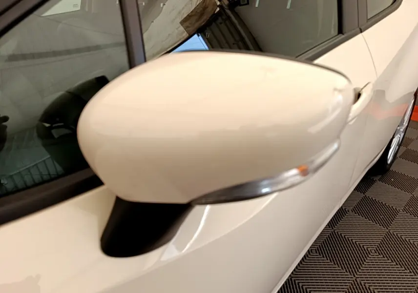 Rétroviseur côté gauche blanc de la Nissan Micra IG-T 92 Acenta 2022 vue en gros plan sur fond intérieur.