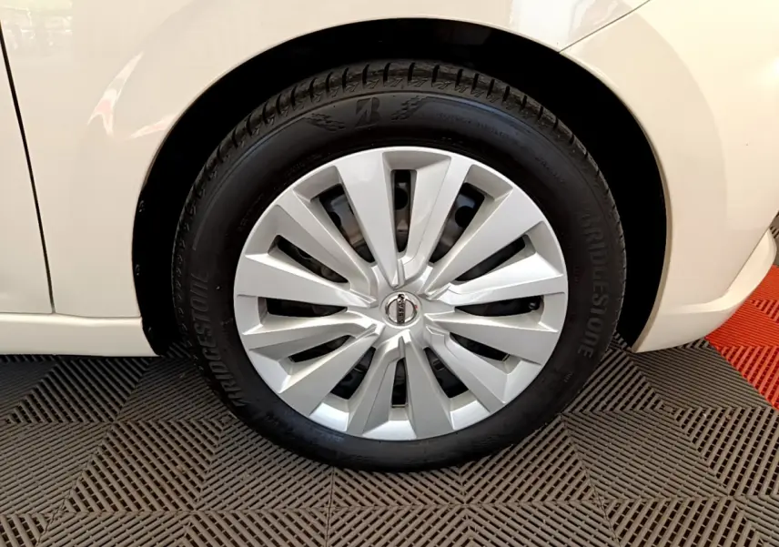 Gros plan sur la roue avant droite d'une Nissan Micra blanche 2022 avec enjoliveur argenté et pneu Bridgestone.