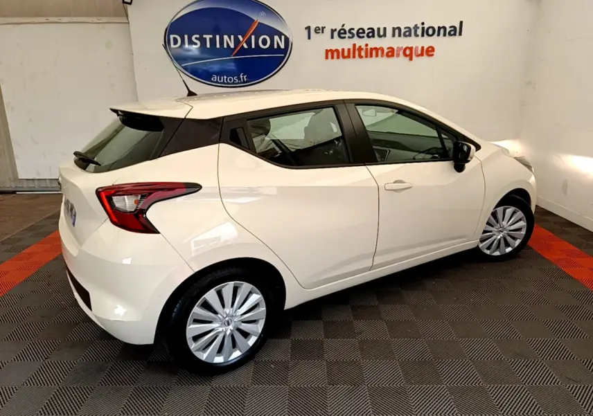 Nissan Micra IG-T 92 Acenta blanche vue de profil côté droit en intérieur avec jantes argentées et feux arrière distinctifs.