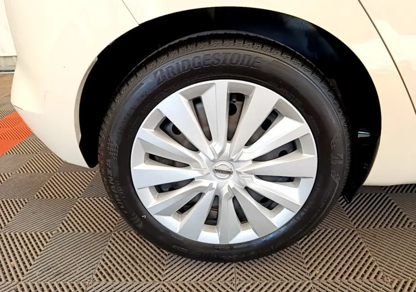 Gros plan sur la roue avant gauche blanche d'une Nissan Micra IG-T 92 Acenta avec jante en alliage argenté.