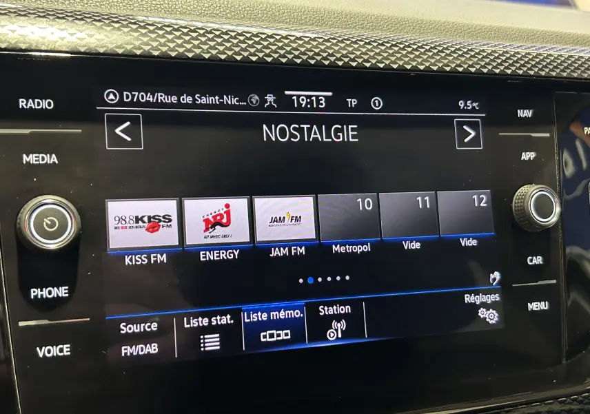 Gros plan sur l'écran tactile central du Volkswagen Polo 2022 noir, affichant les stations radio avec interface moderne.