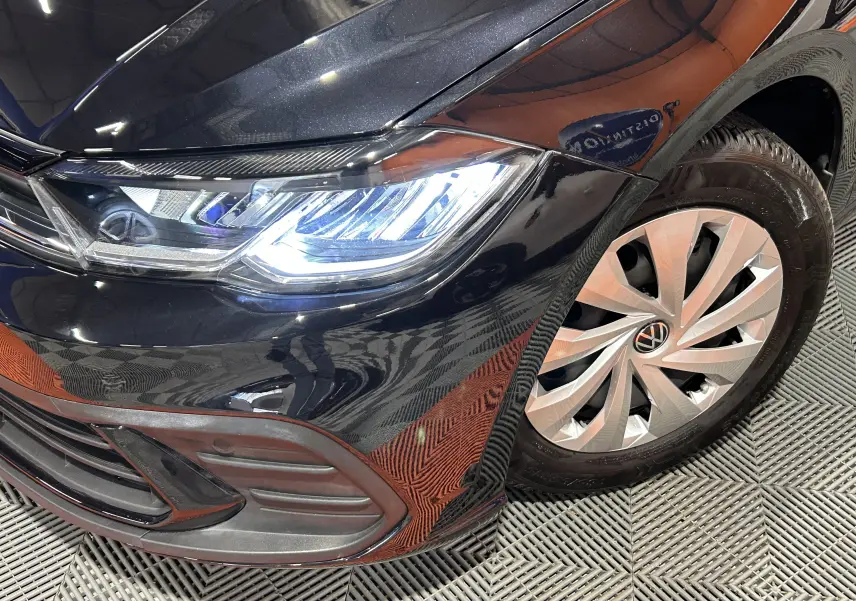 Gros plan sur l'avant droit noir brillant d'une Volkswagen Polo 2022, mettant en valeur le phare LED et la jante alliage.