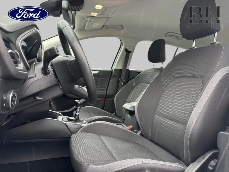 Vue intérieure côté conducteur de la Ford Focus SW 2020, sièges tissu gris et volant cuir multifonction.