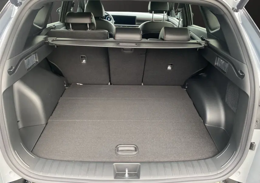 Coffre ouvert vu de l'arrière d'un Hyundai Tucson gris Shadow, avec cache-bagages et sièges arrière en cuir noir.