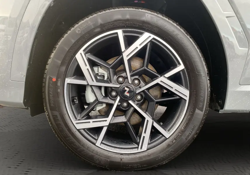 Gros plan sur la jante alu 19 pouces noire et argent du Hyundai Tucson 2026 en couleur Grey Shadow.