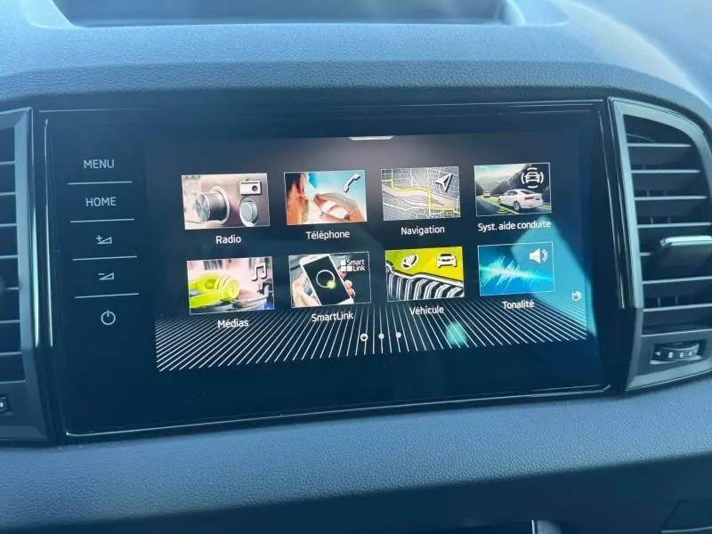Écran tactile central du tableau de bord du Skoda Karoq gris, affichant le menu multimédia et navigation.
