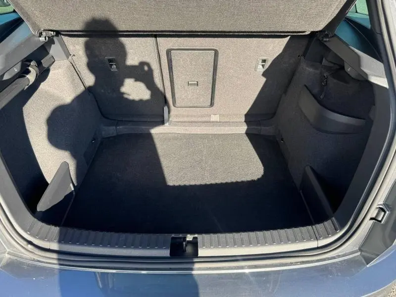 Vue plongeante sur le coffre gris du Skoda Karoq 2025, montrant un espace de rangement propre et bien fini.