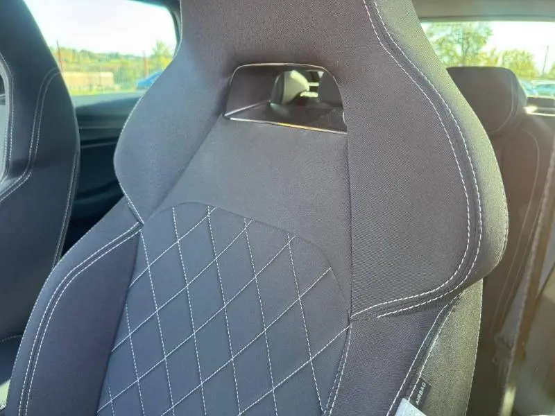 Gros plan sur le siège avant sport noir du Skoda Karoq 2025 avec surpiqûres blanches et appuie-tête intégré.