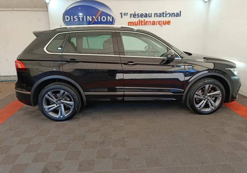 Vue latérale droite d'un Volkswagen Tiguan noir 1.4 eHybrid 2023 avec jantes alliage et toit ouvrant électrique.