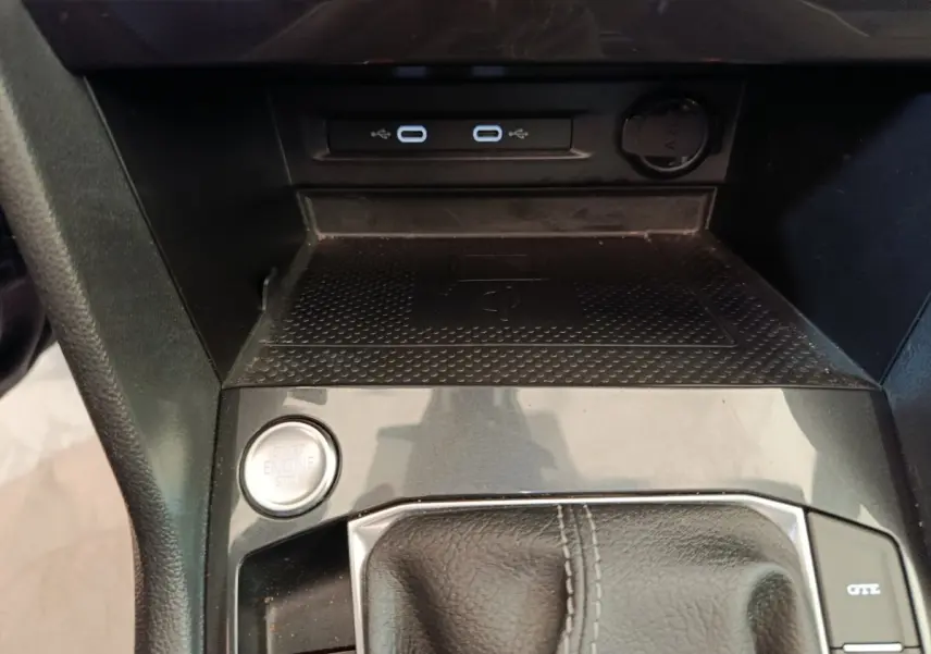Vue rapprochée de la console centrale noire du Volkswagen Tiguan avec bouton start/stop et ports USB-C.