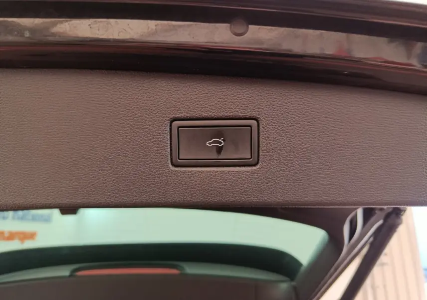 Bouton d'ouverture électrique du coffre sur la partie intérieure du hayon d'un Volkswagen Tiguan noir 2023.