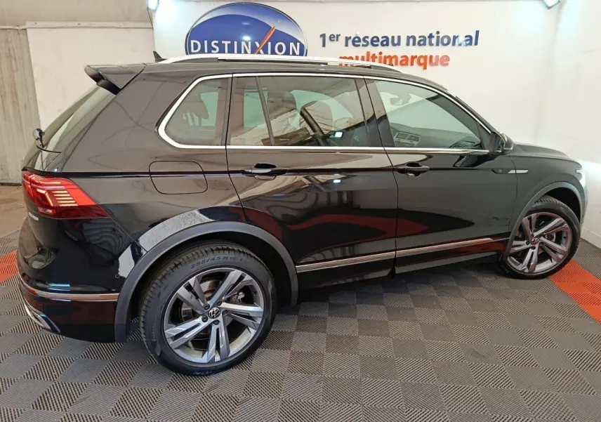 Vue de profil côté droit d'un Volkswagen Tiguan noir 1.4 eHybrid 2023 avec jantes alliage et toit ouvrant.