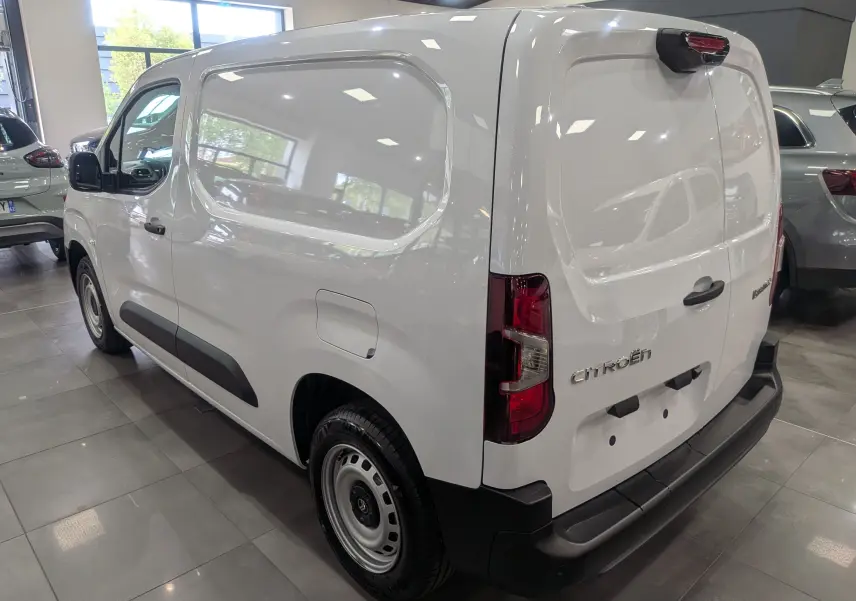 Vue 3/4 arrière droite du Citroën Berlingo Van blanc 2025 avec portes arrière pleines et protections noires.