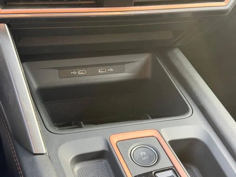 Détail de la console centrale de la SEAT LEON 2025 avec prise USB-C double et bouton de contrôle, finition gris métallique.