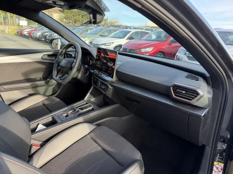 Vue intérieure côté conducteur de la SEAT LEON 2025 gris magnétique, avec tableau de bord moderne et écran tactile central.