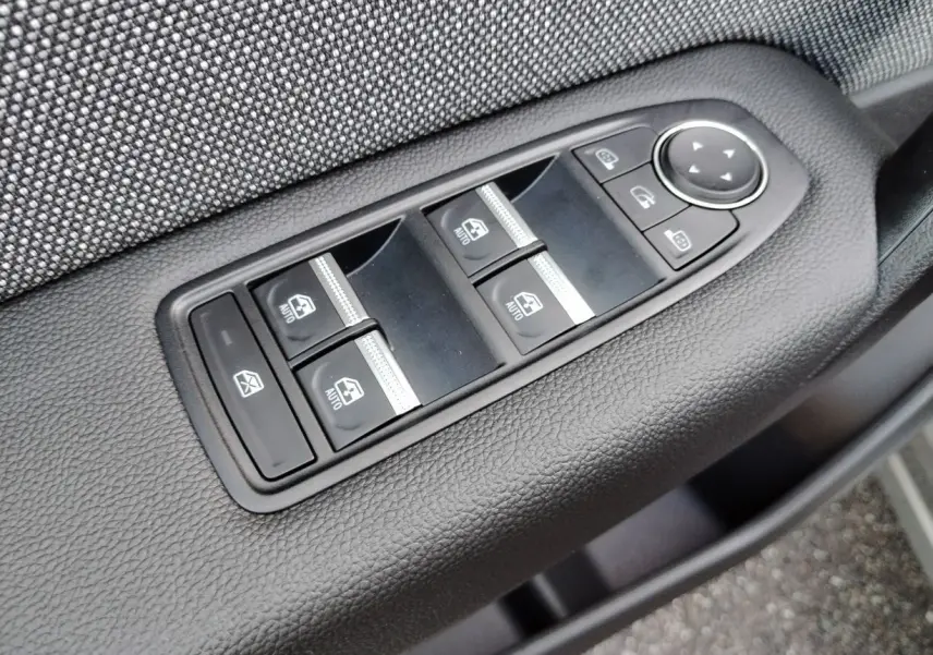 Panneau de commandes des vitres électriques et rétroviseurs sur la porte côté conducteur d'un Renault Captur gris Cassiopée toit noir.