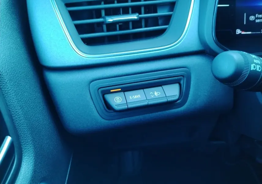 Boutons de commande E-SAVE et réglage des phares sur le tableau de bord noir du Renault Captur E-Tech hybride 2025.