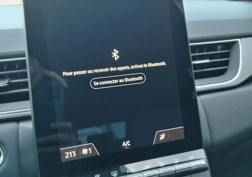 Écran tactile central allumé du tableau de bord du Renault Captur E-Tech gris cassiopée, affichant la connexion Bluetooth.