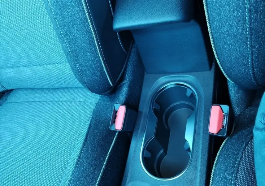 Vue rapprochée de la console centrale avec accoudoir noir et sièges tissu gris du Renault Captur E-Tech 2025.